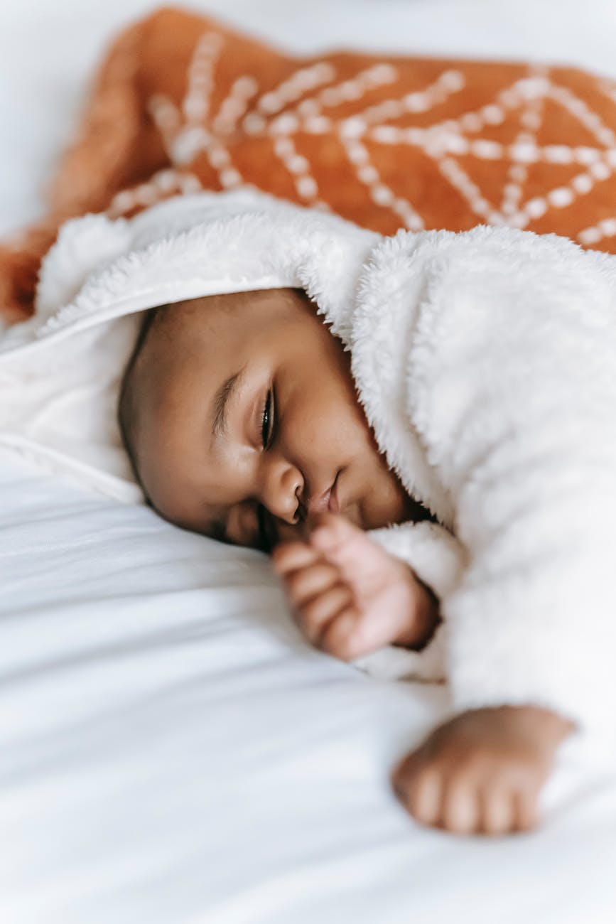 sleeping black infant baby on bed