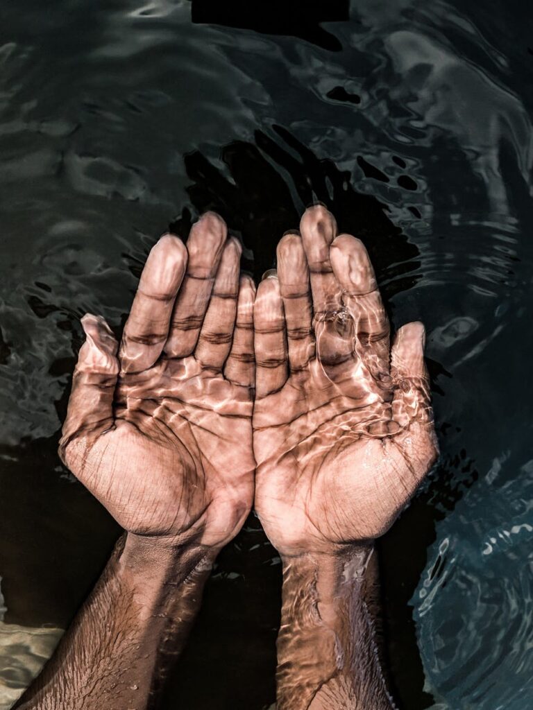 crop man with hands under transparent water