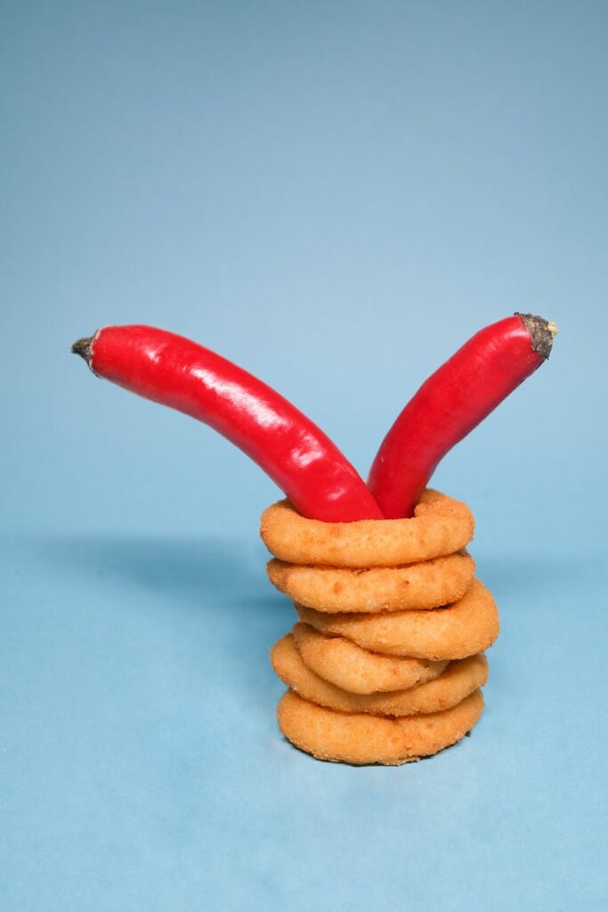 chili peppers in onion rings on blue background