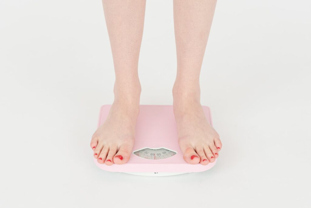 woman checking weight on scales in studio