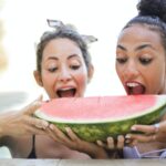 photo of women eating watermelon