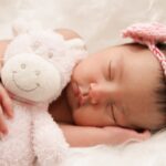 baby sleeping with animal plush toy